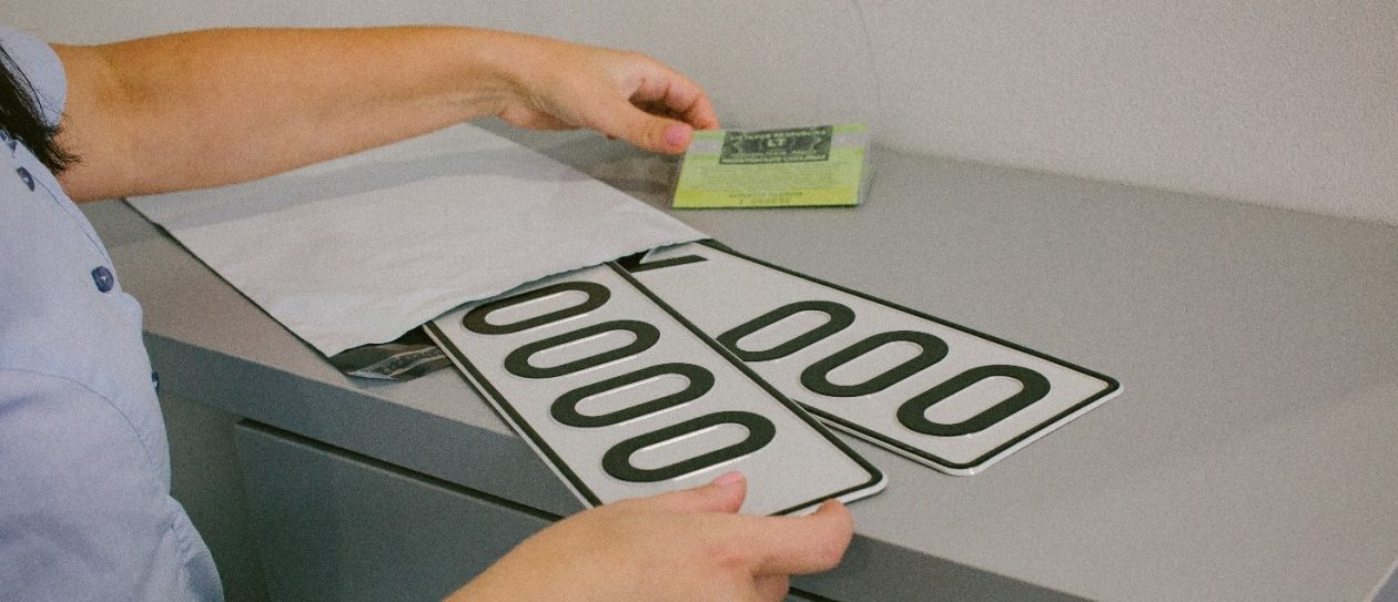 Asmuo laiko transporto priemonės numerio ženklus ir žalią transporto priemomnės registracijos liudijimą